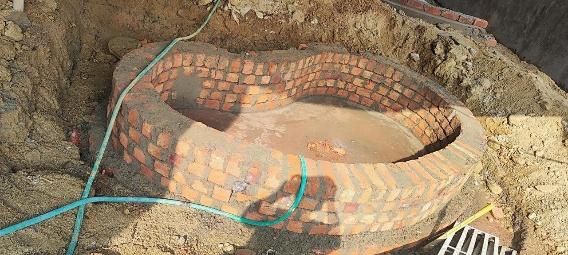 Sandpit and circular brick masonry construction
